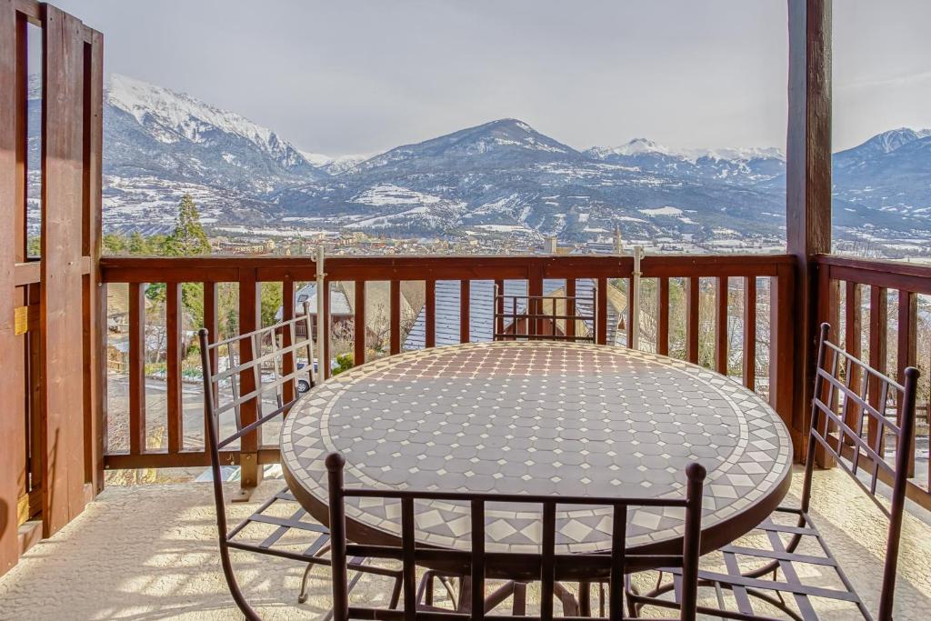 埃姆布能Les Fauvettes - appartement vue imprenable sur montagne的山景阳台上的桌子