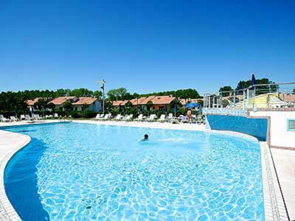利尼亚诺萨比亚多罗Casabianca Resort Villas的在大型蓝色游泳池游泳的人