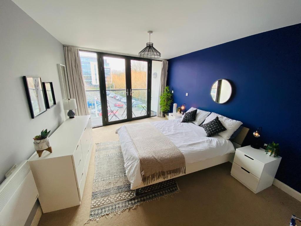 切尔滕纳姆Stewart St James Walk Apartment的蓝色的卧室设有床和大窗户
