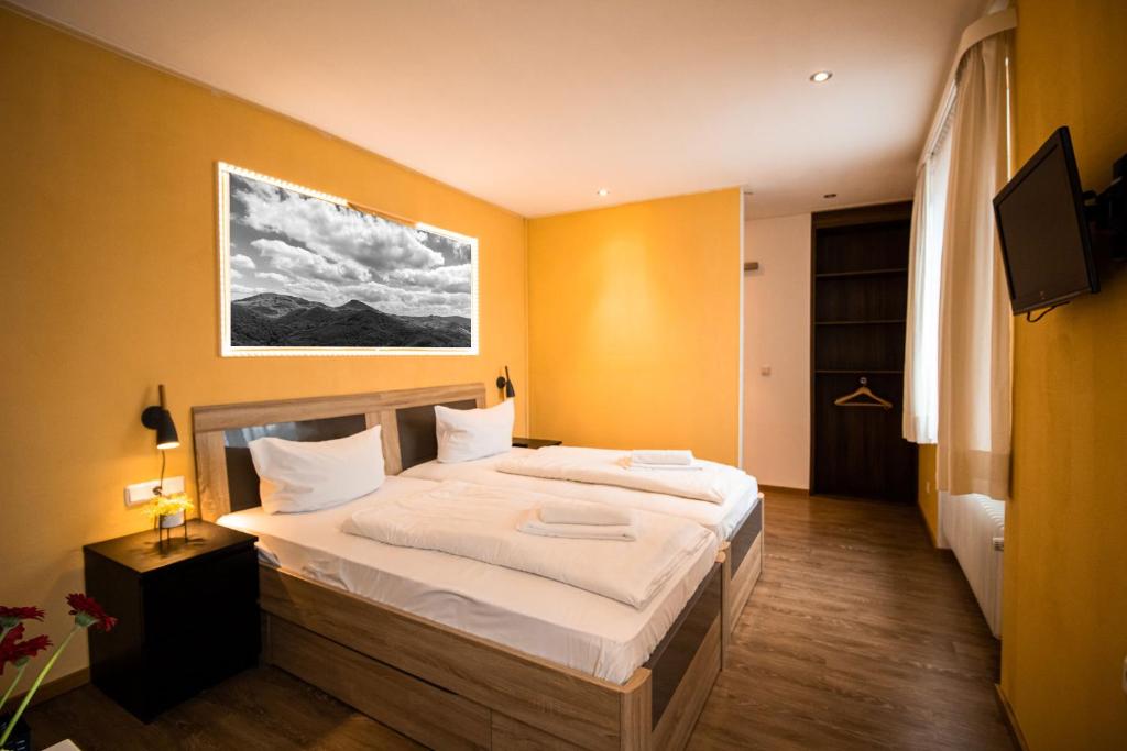 瓦尔斯罗德Hotel Stadtschänke的一间卧室配有一张带白色床单的大床