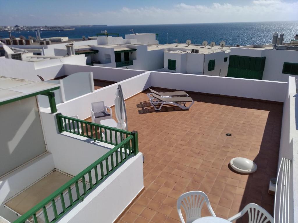 普拉亚布兰卡Apartamentos Casa Cipri的阳台配有椅子,享有海景。