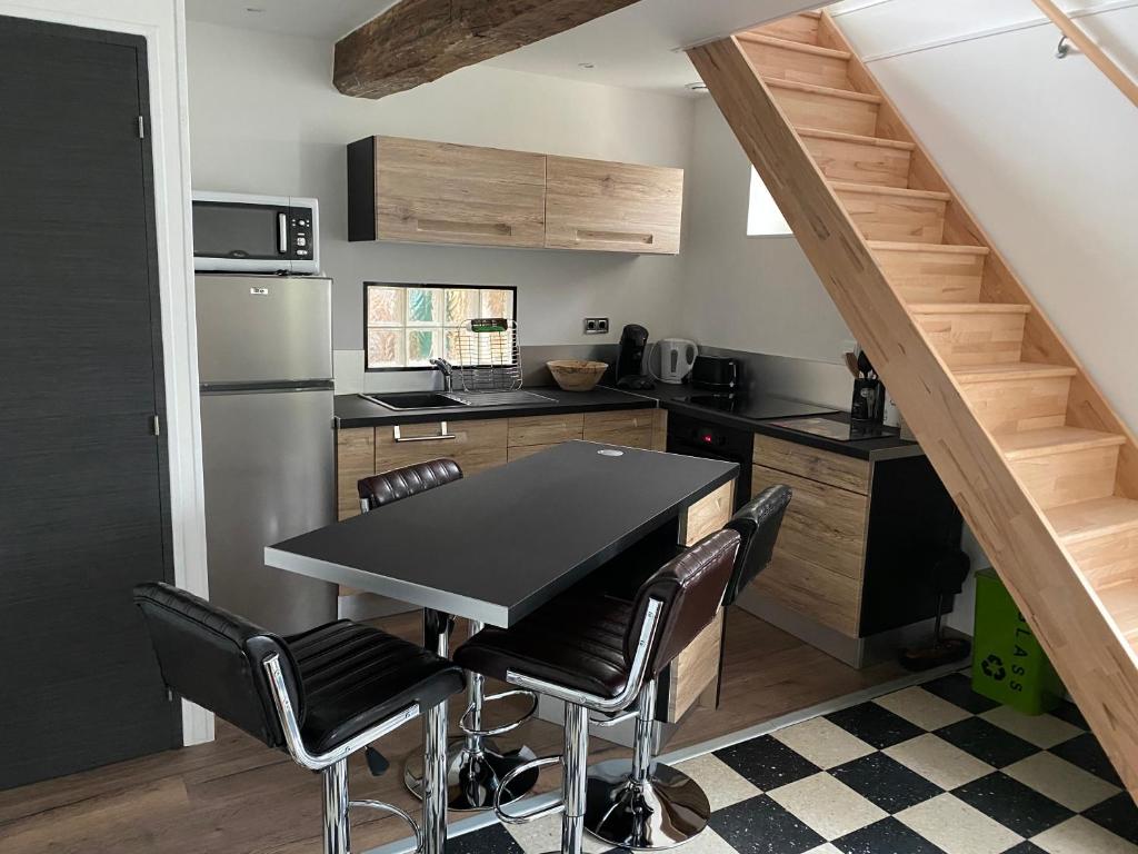 斯里恩库芬cottage Philippe et Valérie的厨房配有黑色的桌子和一些椅子