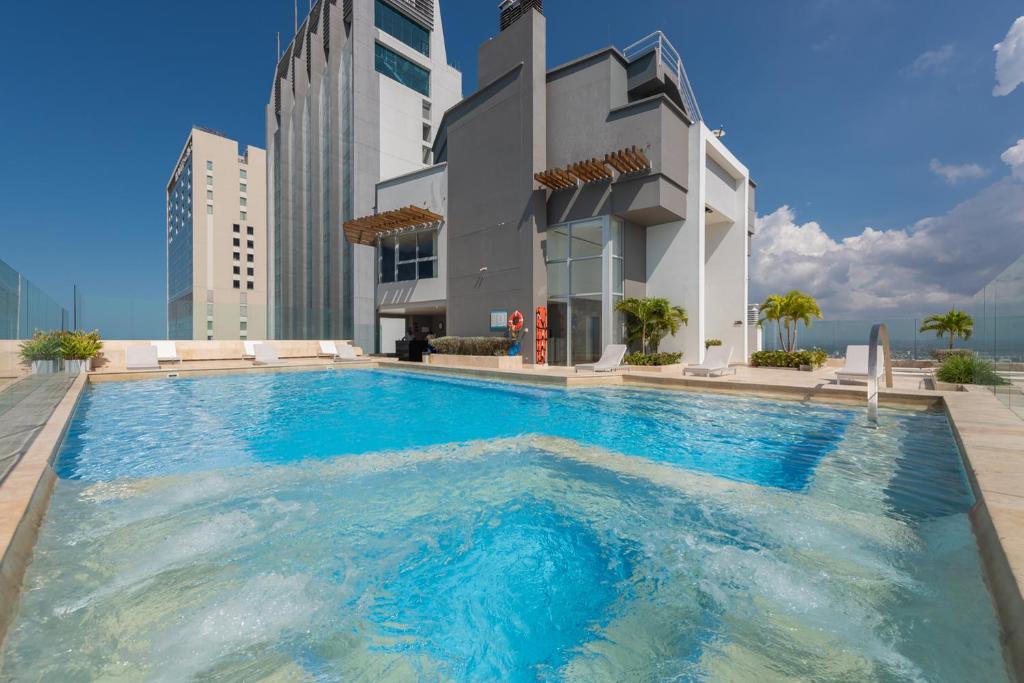 卡塔赫纳MURANO ELITE NEW OCEAN FRONT DUPLEx的大楼前的大型游泳池