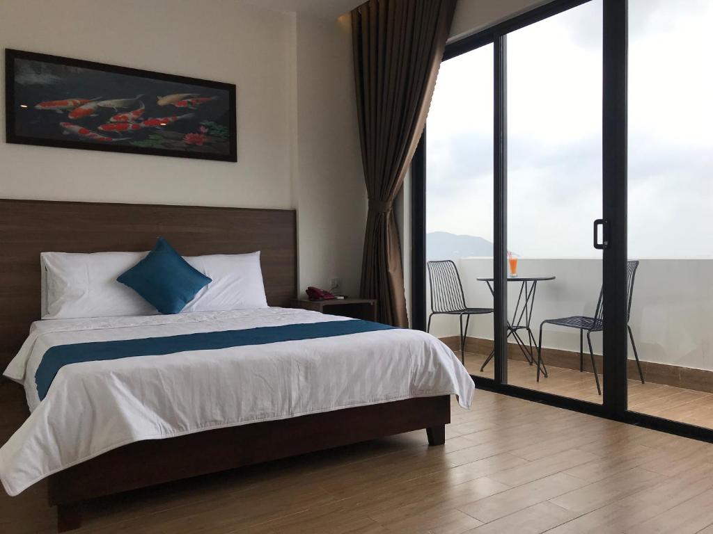归仁Hotel Hoàng Hưng Quy Nhơn的一间卧室配有一张床,阳台配有桌子