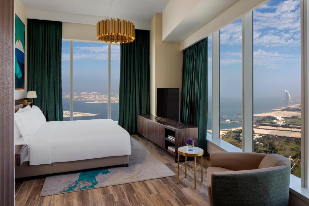 迪拜Avani Plus Palm View Dubai Hotel & Suites的一间卧室设有一张床和大窗户