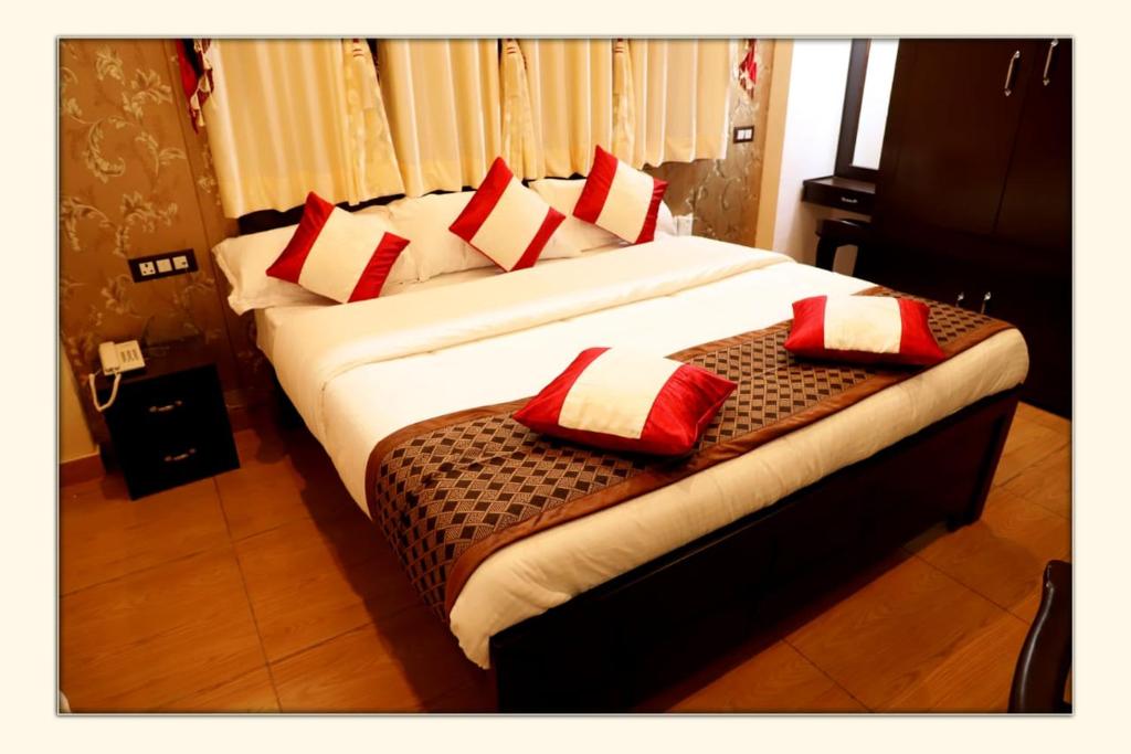 拉尼凯特The Ranikhet Continental的一间卧室配有两张带红白色枕头的床