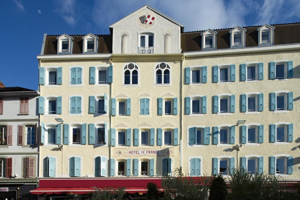 埃维昂莱班法兰西康塔克酒店的一座白色的大建筑,上面有时钟