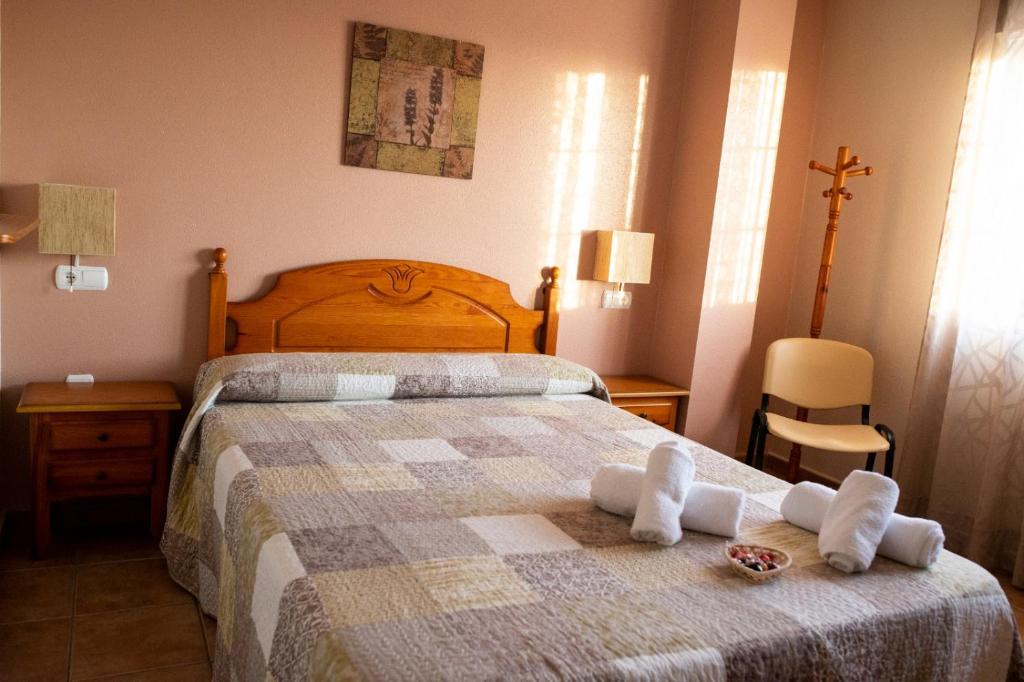 洛斯阿尔卡萨雷斯伊尔科尔多贝斯膳食公寓的一间卧室配有带毛巾的床
