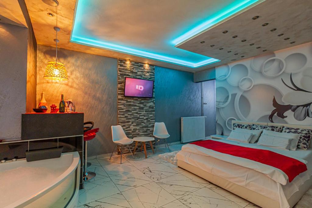 兹拉蒂博尔蓝屋公寓的一间卧室配有一张床、一个浴缸和一台电视。