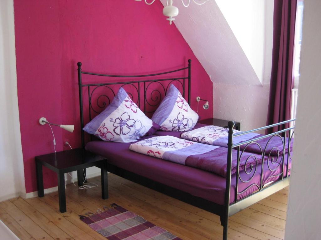 科赫姆Ferienwohnungen Frank的粉红色墙壁的房间里一张床位