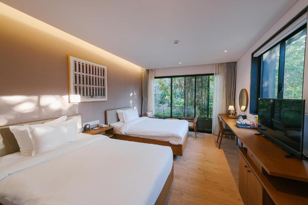 胡志明市BLESSED Hotel的酒店客房设有两张床和一台平面电视。