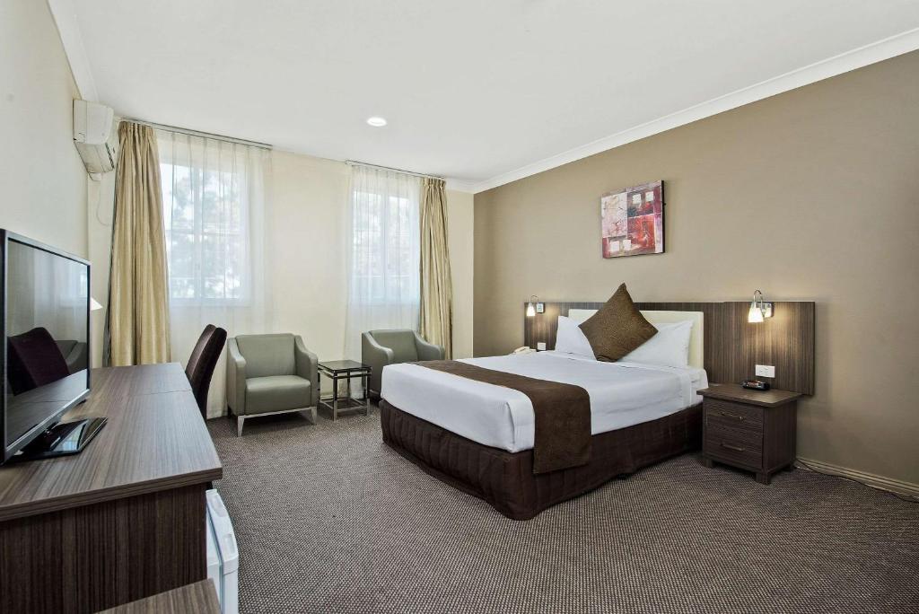 丹德农Comfort Hotel Dandenong的配有一张床和一台平面电视的酒店客房