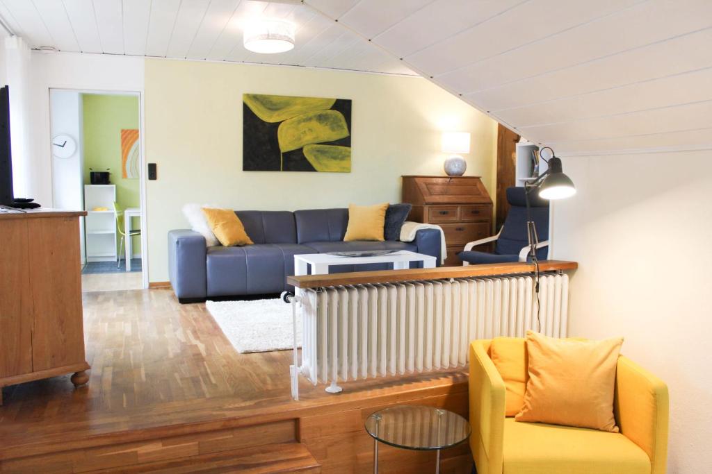 代特莫尔德Ferienwohnung am Stemberg的客厅配有蓝色的沙发和黄色的椅子