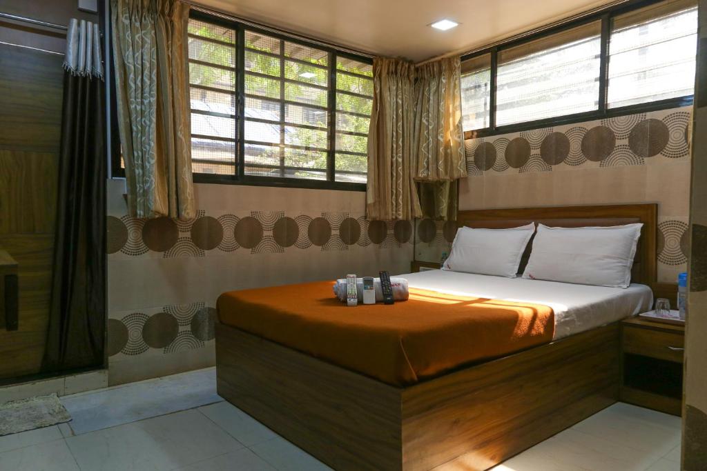 孟买迎宾旅馆的一间卧室设有一张床、淋浴和窗户。