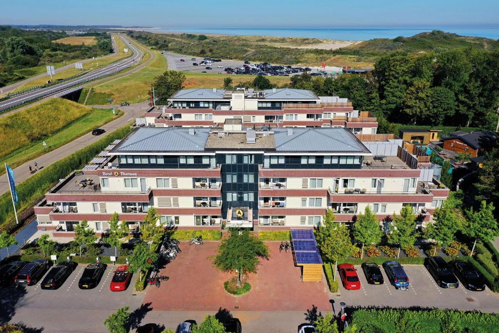 坎珀兰Fletcher Wellness-Hotel Kamperduinen的享有大楼空中景色,设有停车场