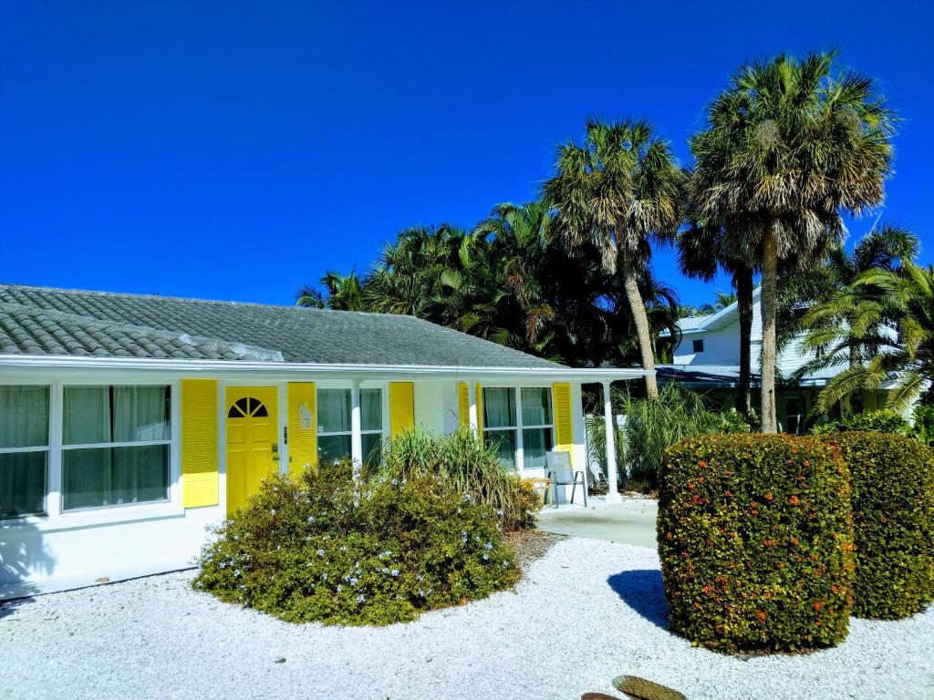 霍姆斯海滩Steps from the Gulf of Mexico II的棕榈树前方的黄色房子