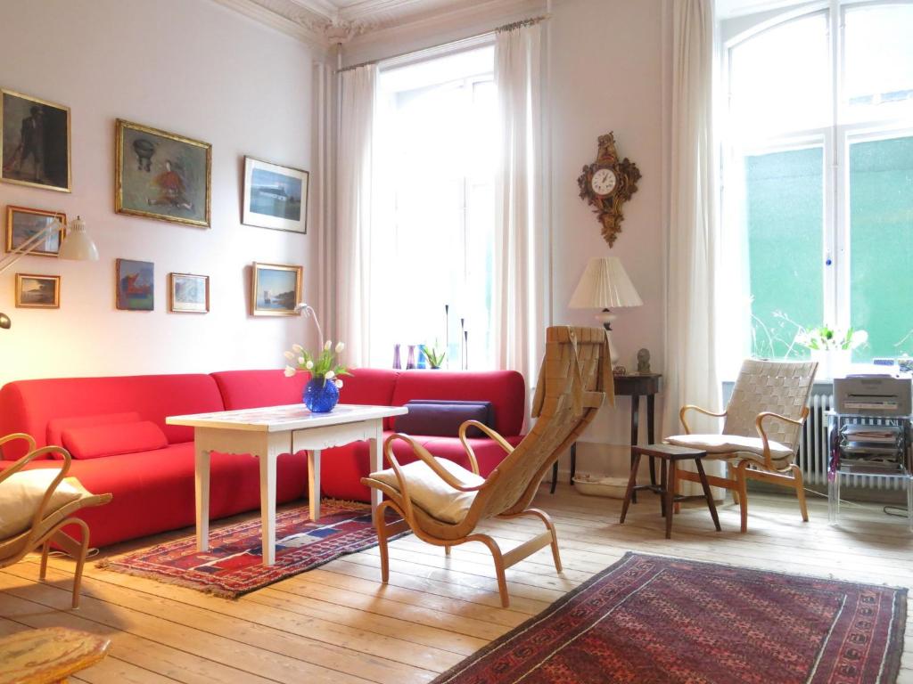 哥本哈根ApartmentInCopenhagen Apartment 931的客厅配有红色的沙发和桌子