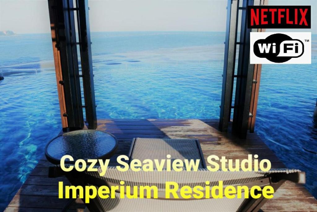 关丹Cozy Seaview Studio at Imperium residence Tanjung Lumpur Kuantan的码头上设有长凳的海景客房