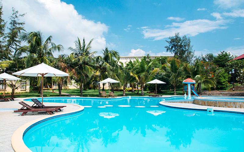 罗夷拉兹海滩度假酒店的一个带椅子和遮阳伞的大型游泳池