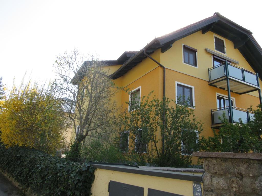 萨尔茨堡霍伊贝格公寓酒店的前面有栅栏的黄色房子