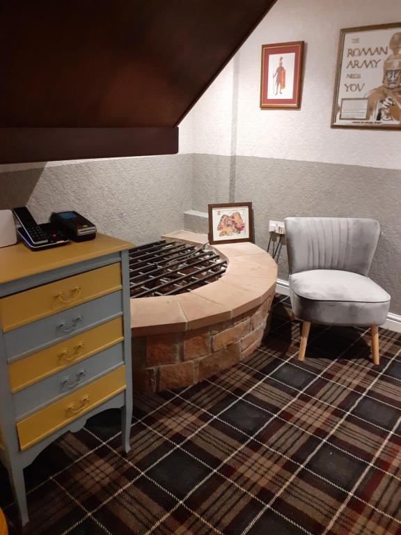 卡莱尔十字路口旅馆的客房设有一张带桌子和椅子的床。