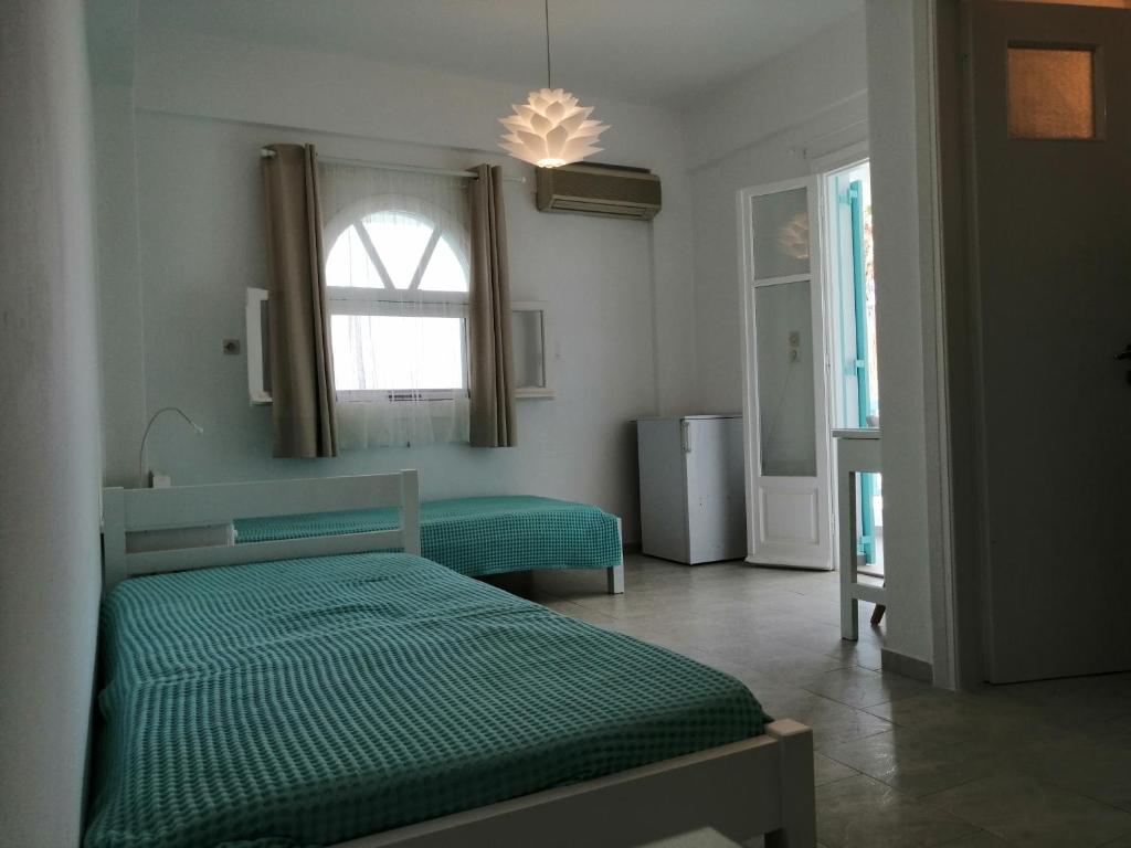 艾丽奇Aliki Panorama Rooms的一间卧室设有两张绿色的床和窗户