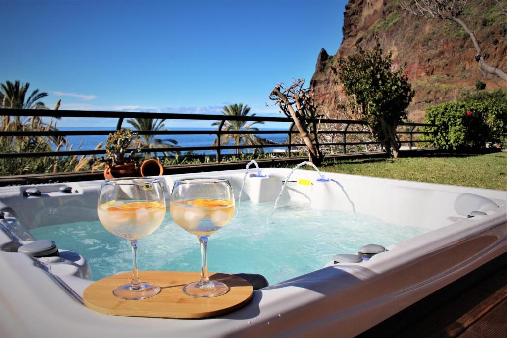 Madalena do MarSunset Sea Breeze的两杯葡萄酒坐在热水浴缸中