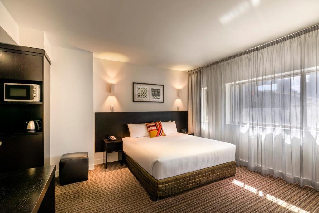墨尔本铜锣湾353酒店的酒店客房设有床和窗户。