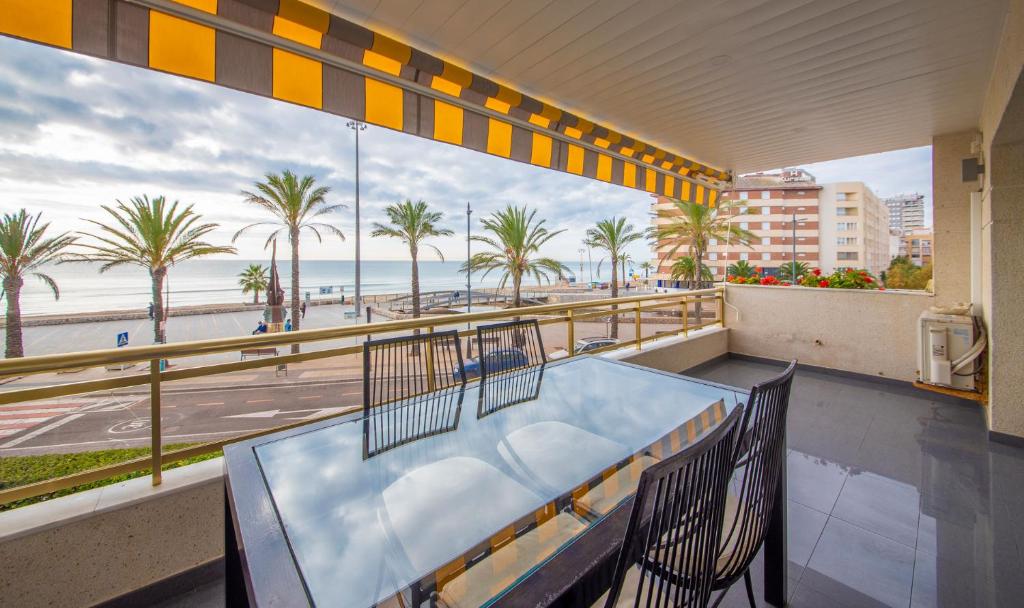 卡拉费尔R114 Apartment Ca La Laura的享有海滩和棕榈树景致的阳台