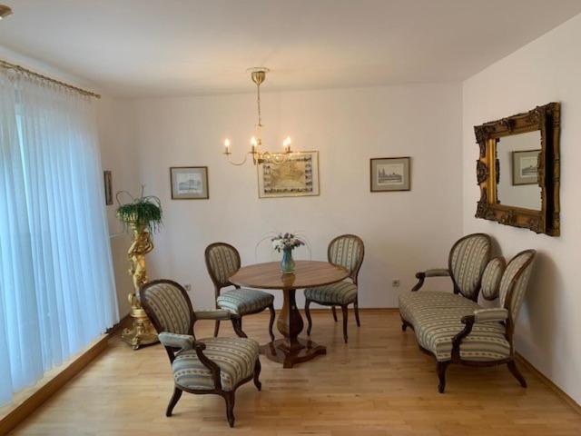 巴登Amadeus Apartment的一间带桌椅和镜子的用餐室