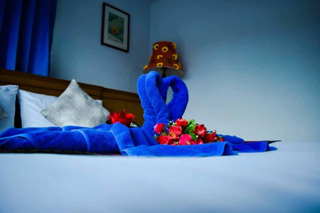 功孟海滩拜林旅馆的床上有蓝色的动物和鲜花