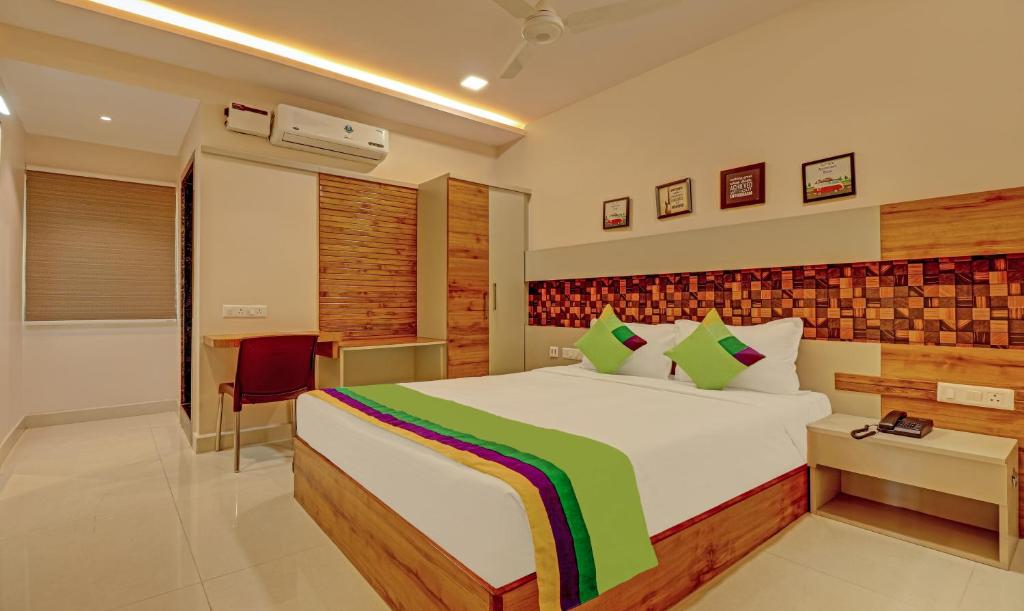 维沙卡帕特南Treebo Trend Rainbow Grand的一间卧室配有一张大床和一张书桌