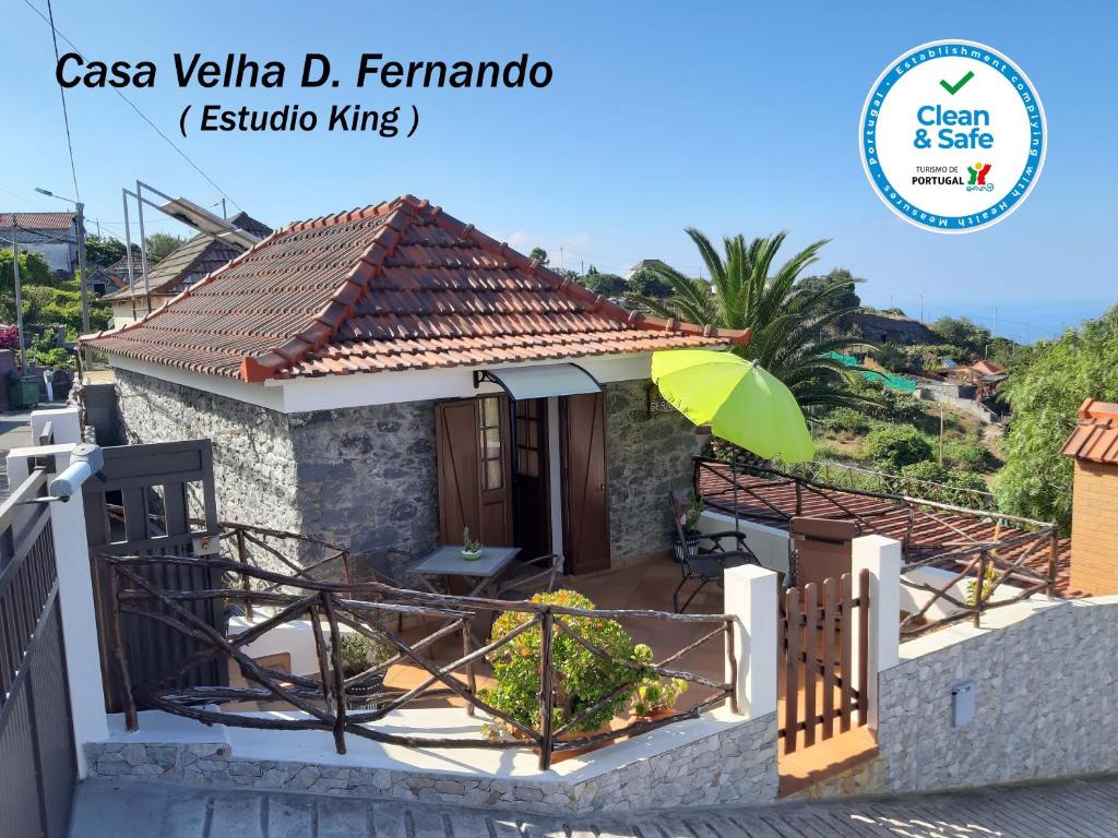 里韦拉布拉瓦Casa Velha D Fernando e Casa Avó Augusta的前面有一把绿伞的小房子