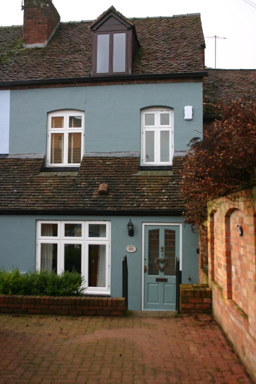 布由德利Corner Cottage的蓝色的房子,设有蓝色的门和窗户