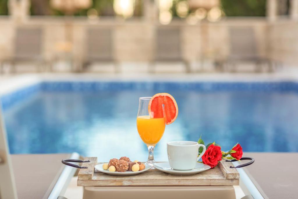 佩特罗瓦纳莫鲁Luxury Apartments Queen的一张桌子,上面放着一杯橙汁和一盘食物