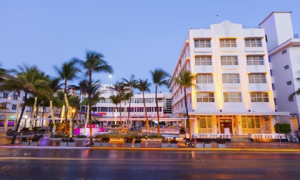 迈阿密海滩克利夫兰德酒店的街道前方有棕榈树的建筑