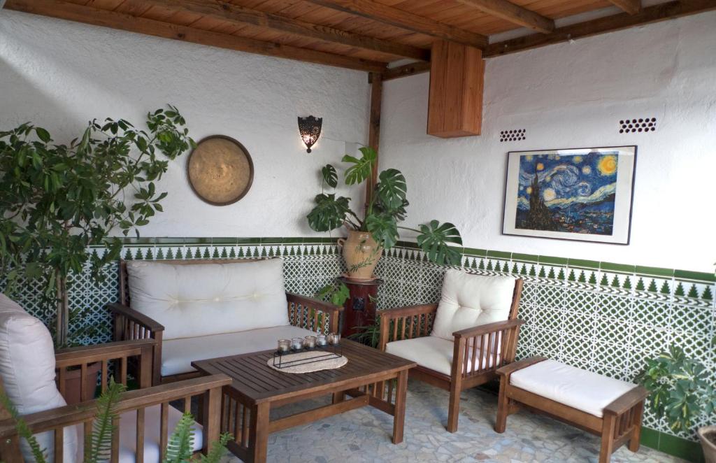 格拉纳达LA CASA DE LOS PINTORES, junto al centro de Granada的庭院配有桌椅和桌椅