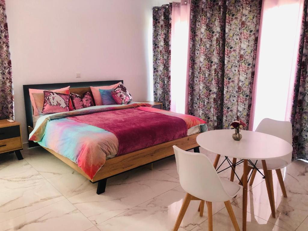拉纳卡Mobina Villas的卧室配有一张床和一张桌子及椅子