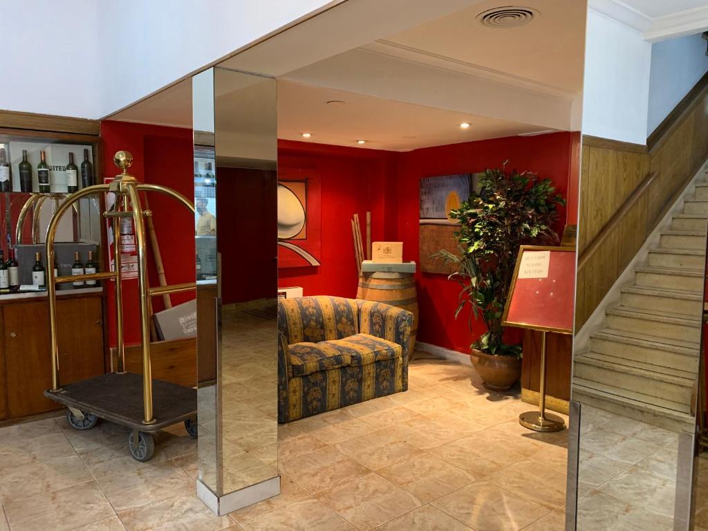 门多萨Palace Hotel Mendoza的大堂设有红色的墙壁和椅子,楼梯
