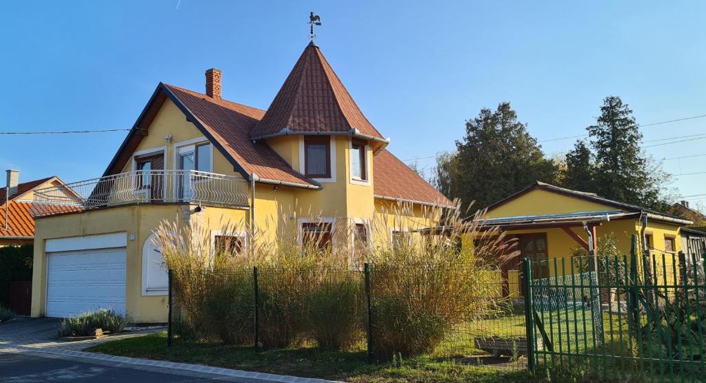 巴拉通马里亚弗都Hajas Família Kiadó Szobák的棕色屋顶的黄色房子