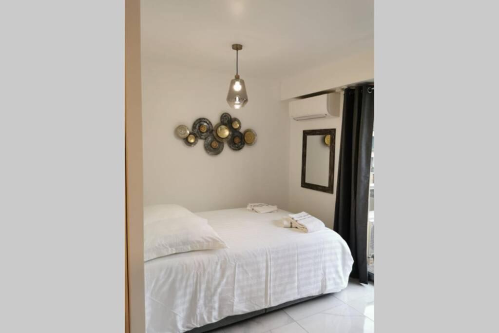 尼斯Cosy Studio 200 m from Nice Beach & Promenade des Anglais的卧室配有白色的床和镜子