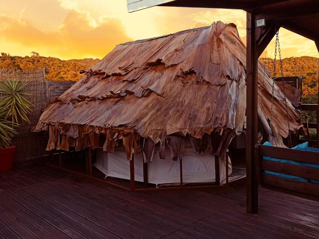 圣吕斯Kawaida - Hébergement insolite - Glamping Makazi的甲板顶上的茅草屋顶
