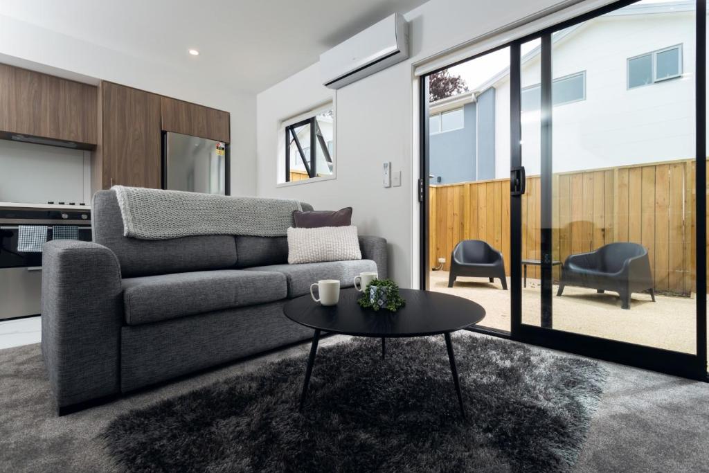 基督城Armagh 221 - Christchurch Holiday Homes的客厅配有沙发和桌子