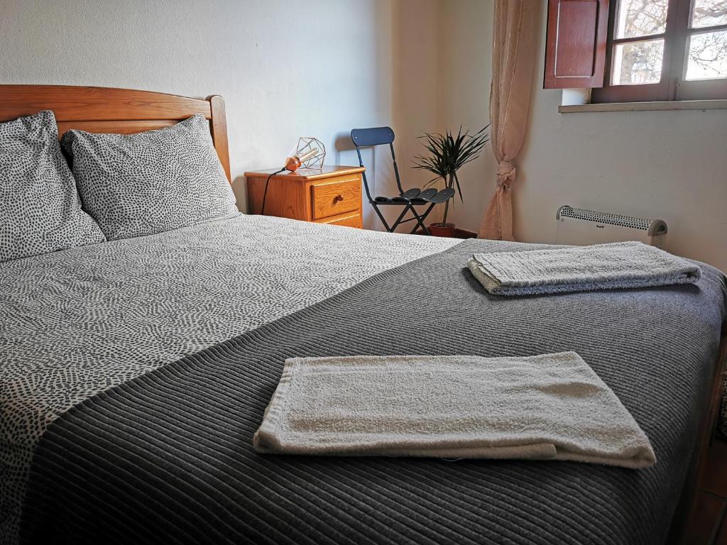 奥比多斯Óbidos - Casa do Castelo的一间卧室配有一张床,上面有两条毛巾