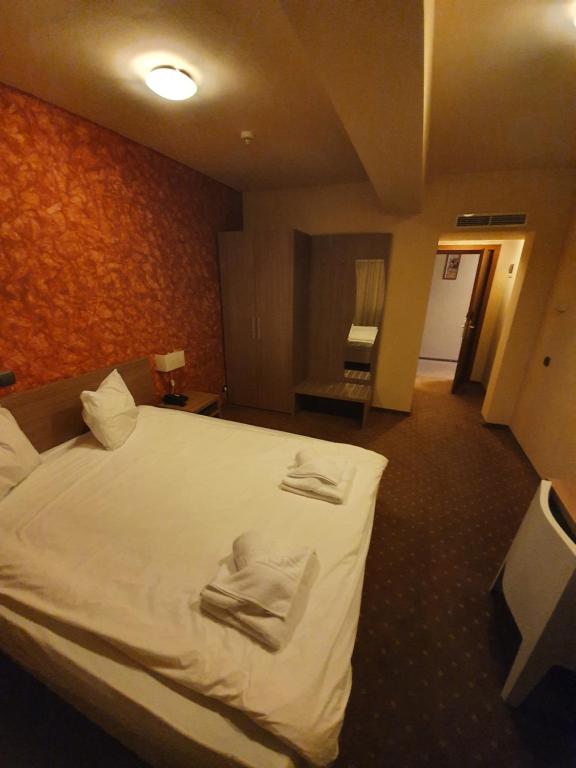 GherlaMerion的酒店客房,配有带毛巾的床