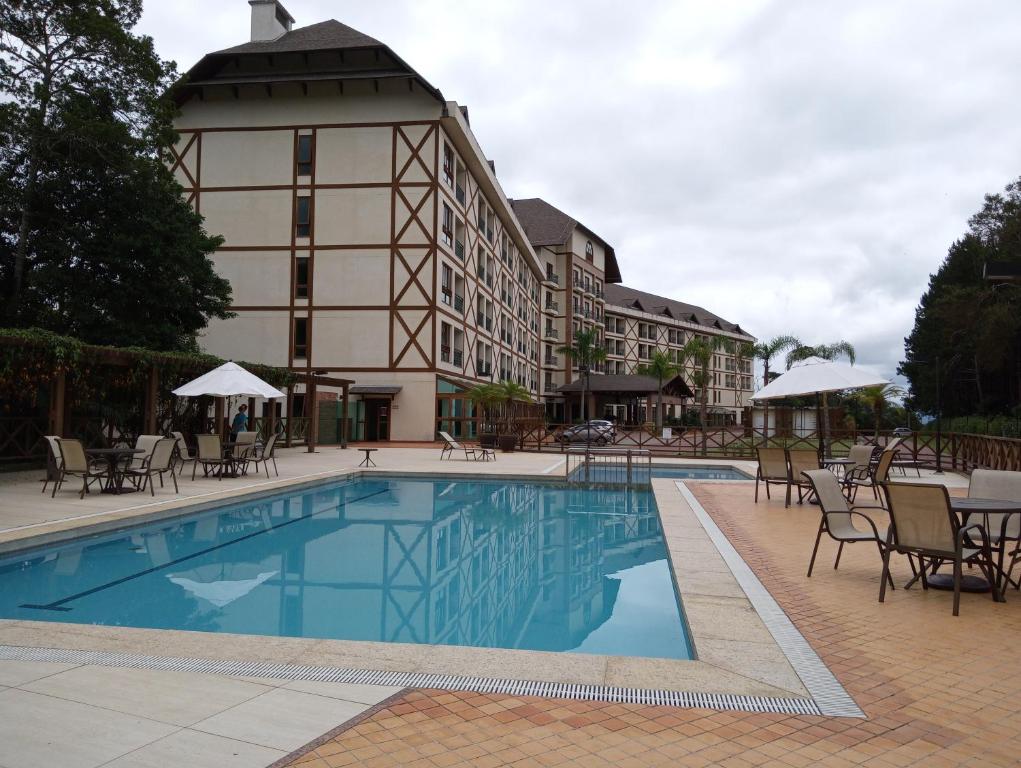 佩德拉阿祖尔Flat em Pedra Azul的大楼前设有游泳池的酒店