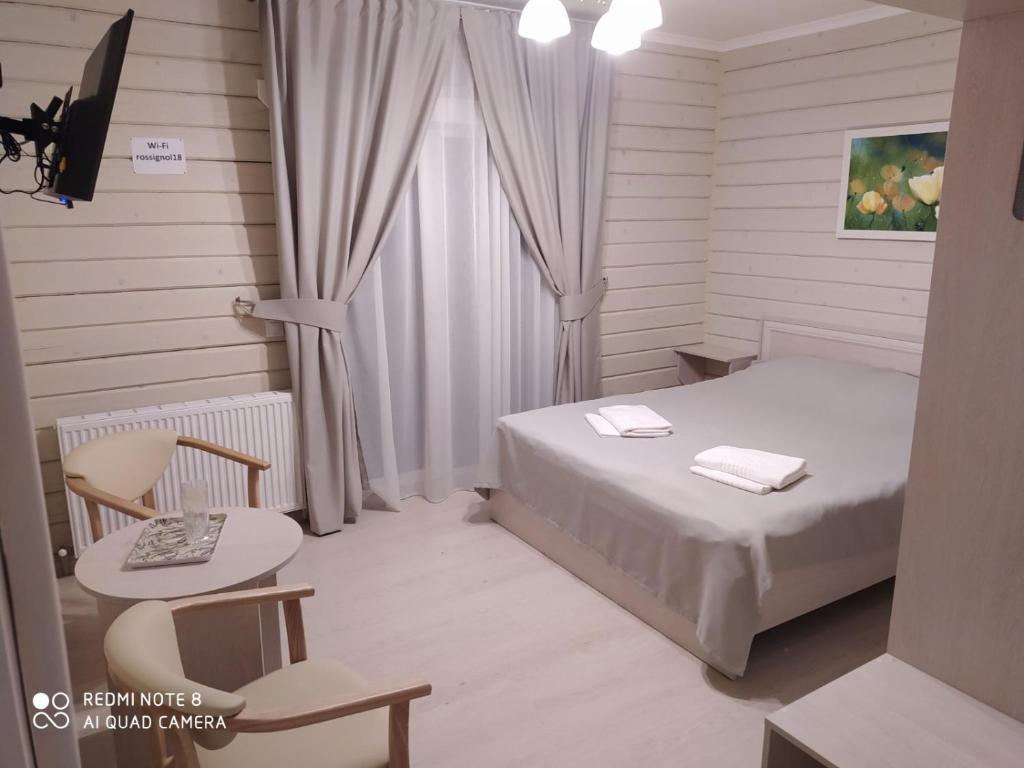 斯拉夫西克Pogar White的一间卧室配有一张床、一张桌子和一个窗户。