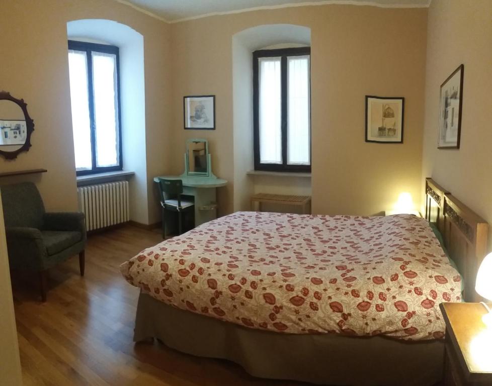 加尔达Palazzo Fregoso的一间卧室配有一张床、一把椅子和窗户。