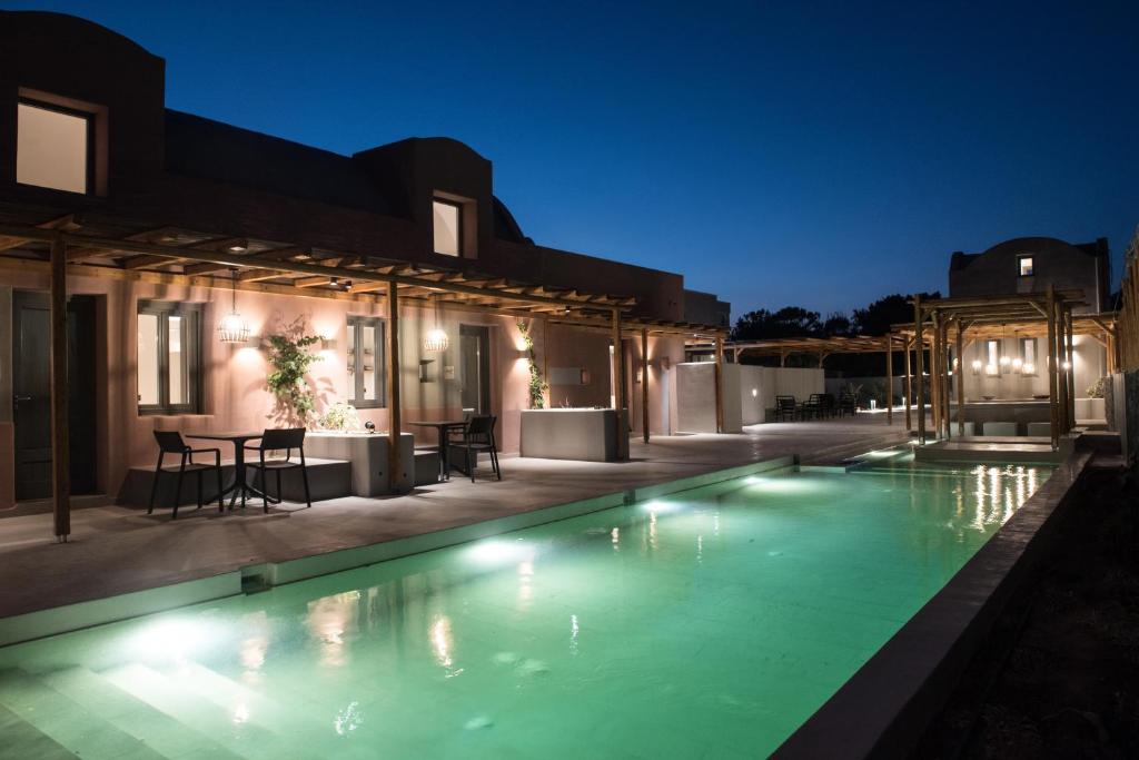 佩里沃罗Terra Nera Suites的夜间在房子里的一个游泳池