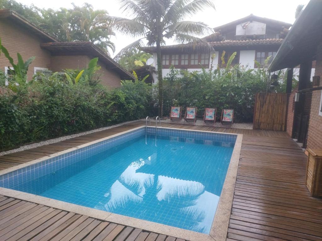 乌巴图巴Casa na praia de Itamambuca na cidade de Ubatuba的一个带木甲板的庭院内的游泳池